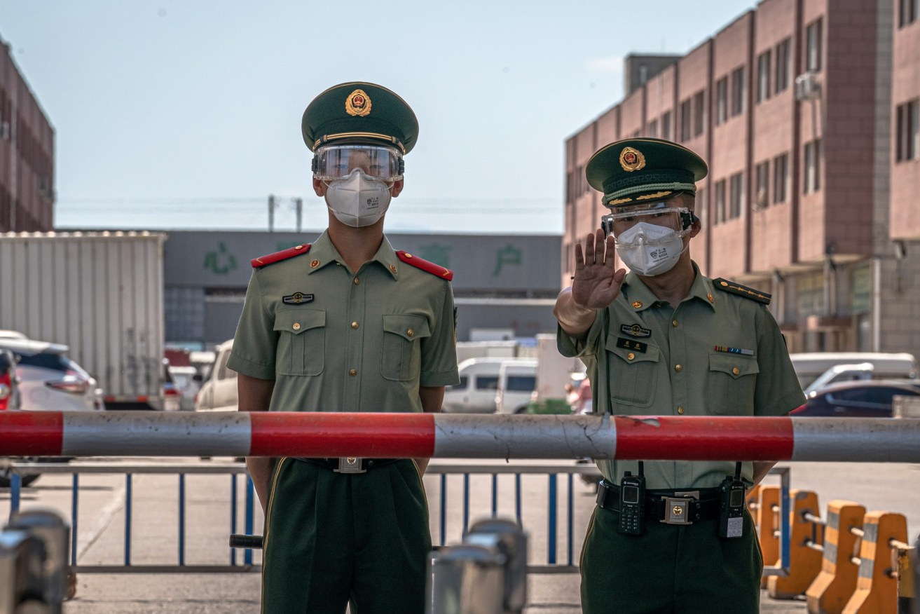 Beijing police guard a closed market in a locked-down area following new domestic coronavirus cases. Photo: EPA/ROMAN PILIPEY