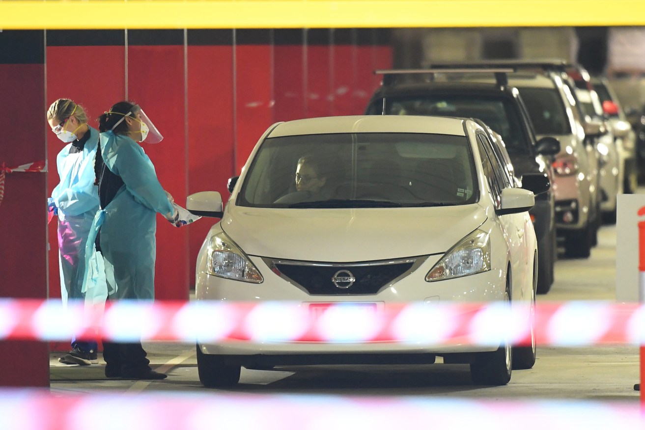 Healthcare workers carry out drive-through COVID-19 tests in Melbourne. Photo: AAP/James Ross 