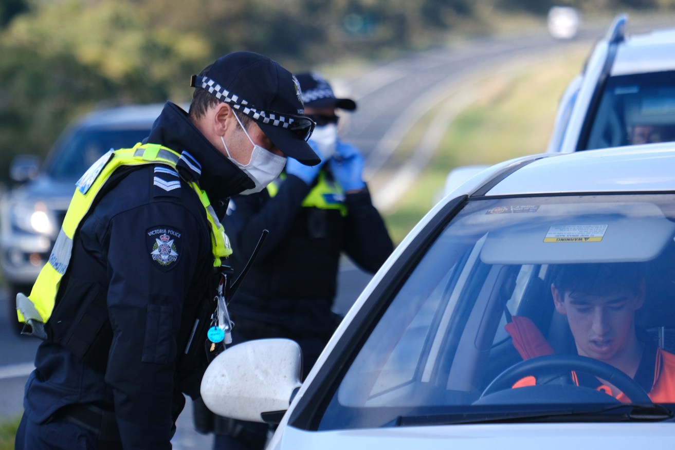 Victorian police check drivers outside locked-down Melbourne. Photo: AAP/Luis Ascui