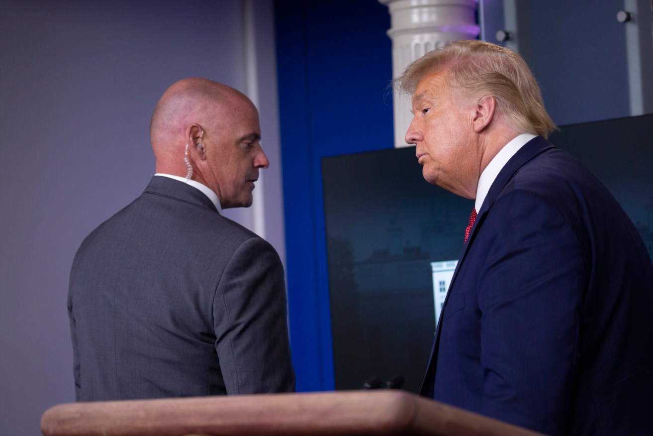 A Secret Service officer escorts Donald Trump from a White House briefing room. Photo: EPA/Stefani Reynolds