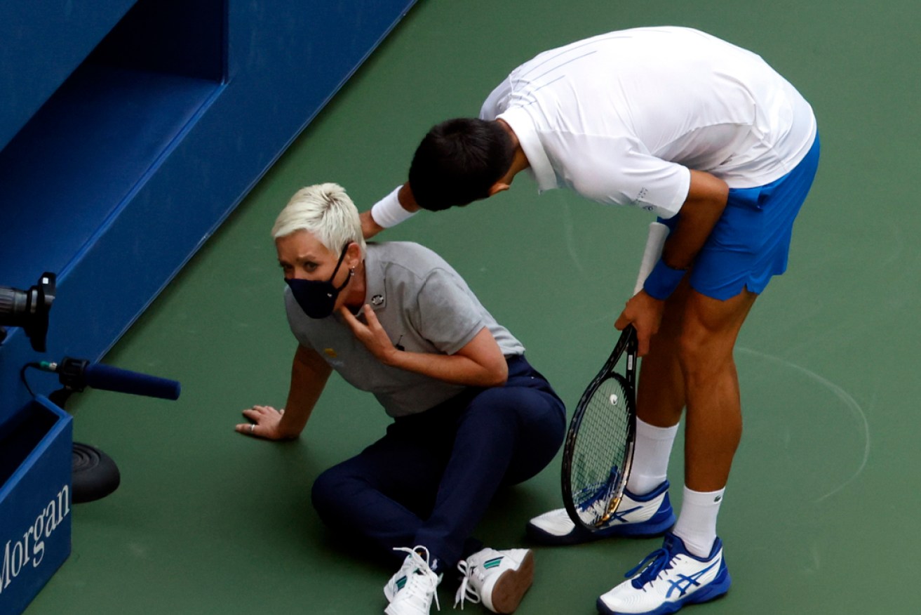 Novak Djokovic tries to help a lines judge after hitting her with a ball in the throat during his match against Pablo Carreno Busta. Picture: Jason Szenes/EPA.