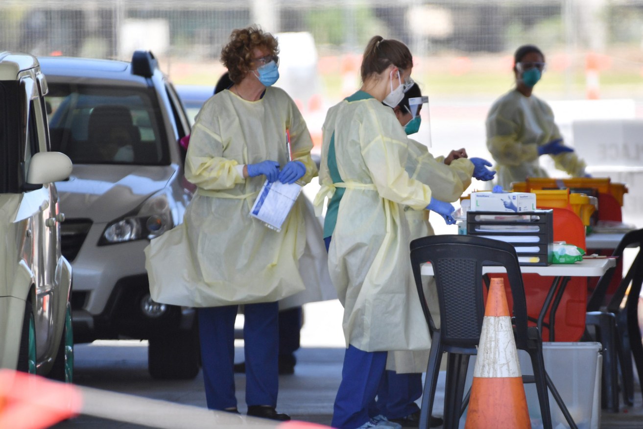 Health workers at an Adelaide testing clinic last week. A new positive test has emerged tonight. Photo: David Mariuz / AAP 