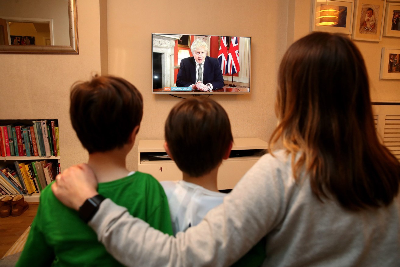 A family watches as UK Prime Minister Boris Johnson announces new restrictions. Photo: Martin Rickett/PA Wire