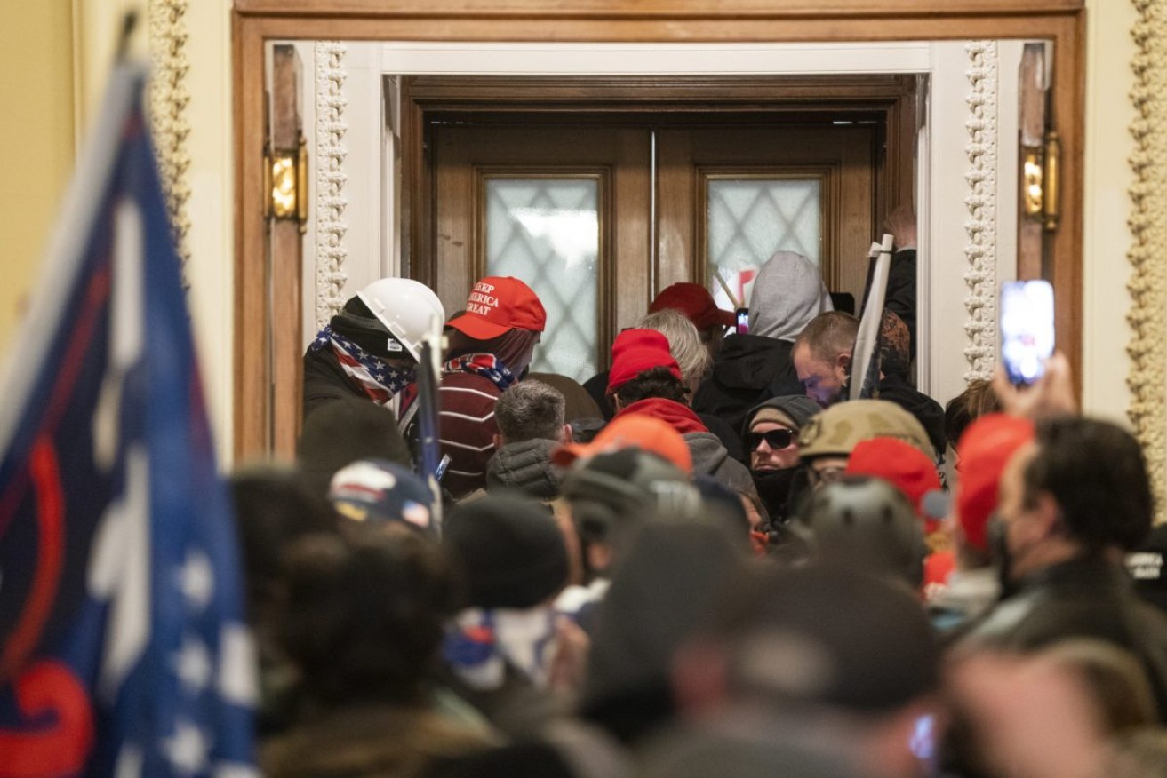 Trump supporters who broke into the US Capitol gather outside the House of Representatives where Congress was ratifying the former president's election loss. EPA/JIM LO SCALZO