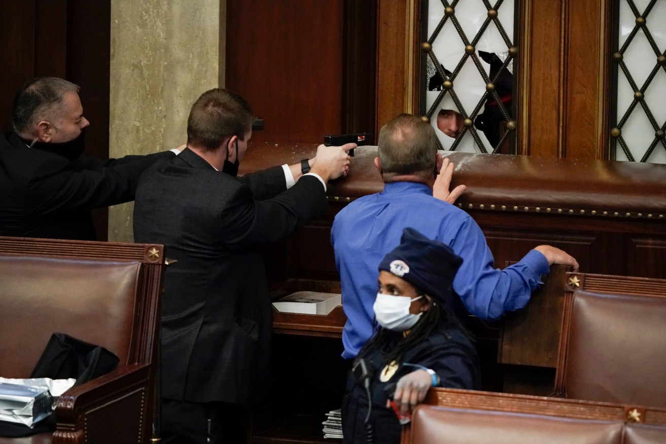 Armed police barricaded the House Chamber at the U.S. Capitol on January 6 2020 to stop Trump supporters entering in a bid to stop Congress ratifying the former president's election loss. Photo: AP/J. Scott Applewhite