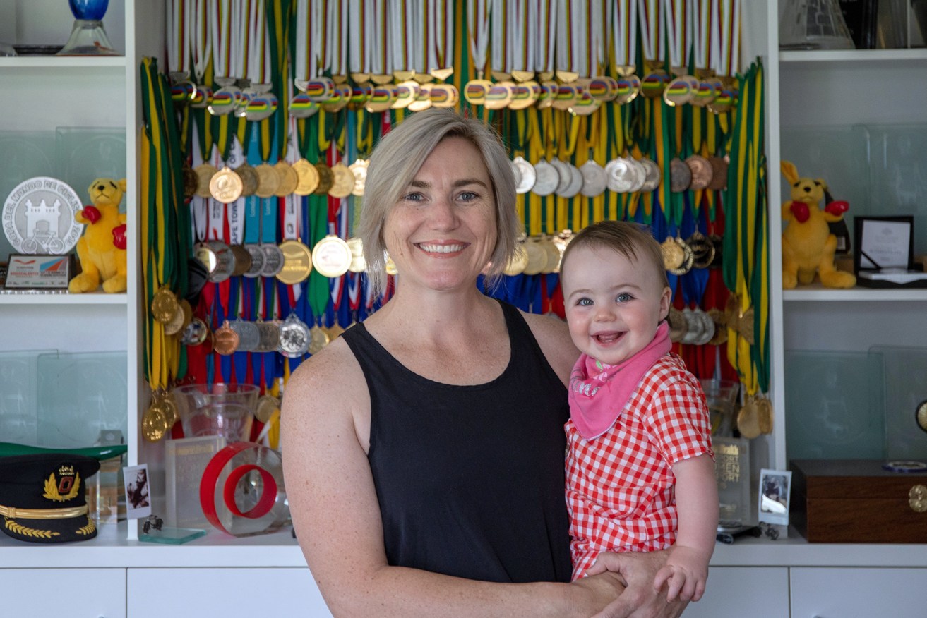 Anna Meares with baby Ev (Evelyn) and her huge haul of cycling medals. Photo: Tony Lewis/InDaily