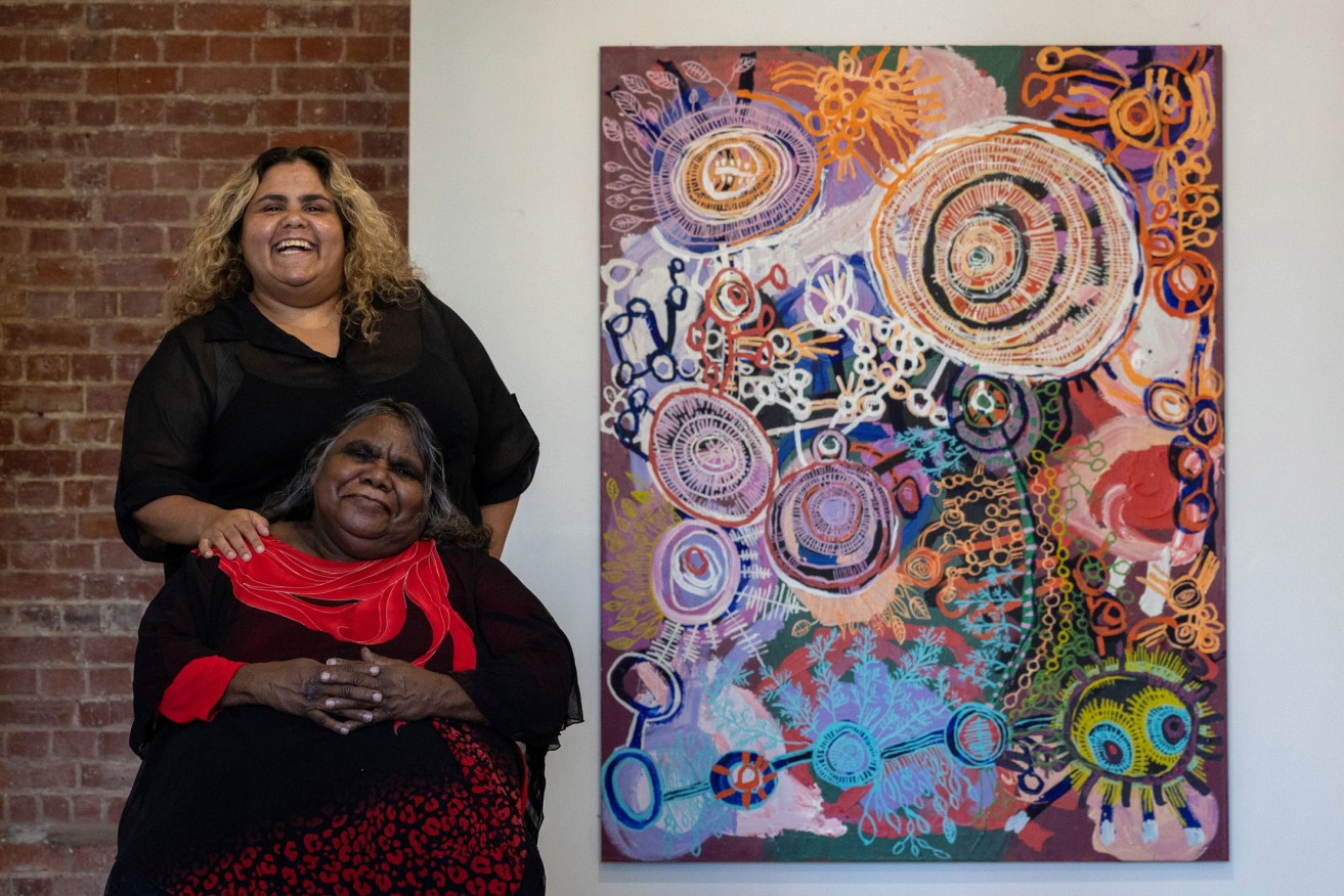 Sally Scales and Josephine Mick alongside one of Scales' paintings at the APY Gallery in Light Square. Photo: Tony Lewis