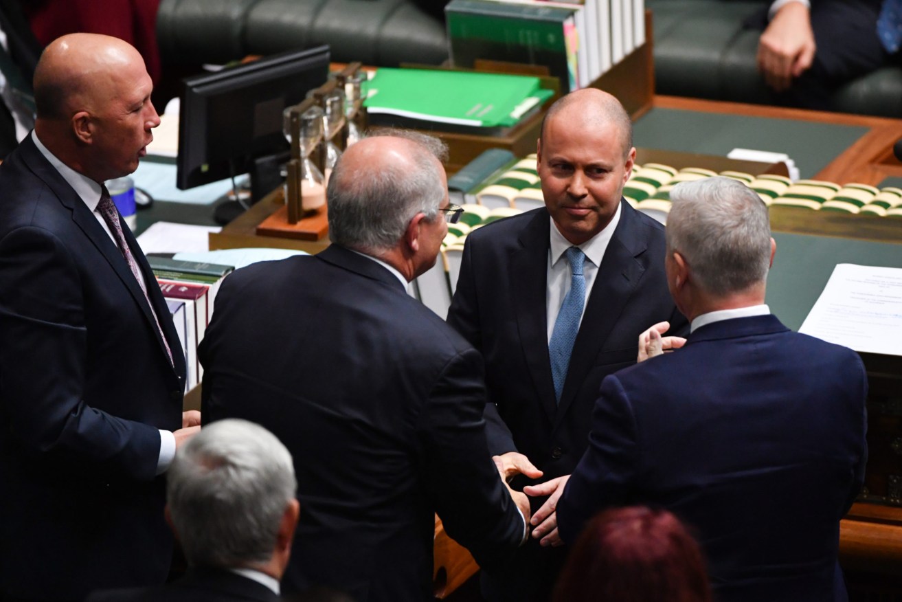Treasurer Josh Frydenberg is congratulated by Prime Minister Scott Morrison after delivering the 2021-22 Budget in the House of Representatives at Parliament House in Canberra, Tuesday, May 11, 2021. (AAP Image/Mick Tsikas)