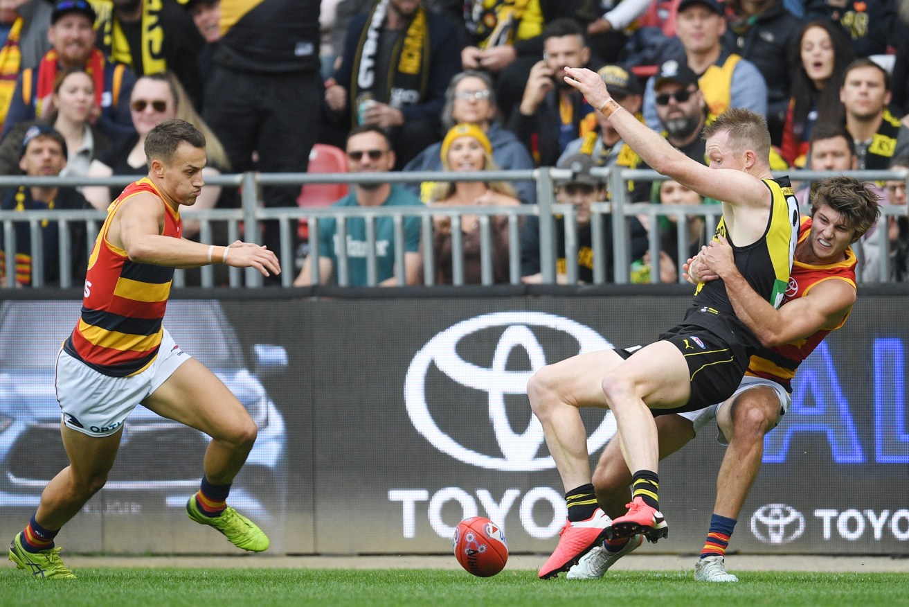 Jack Riewoldt drops the ball in a Jordon Butts tackle, which naturally results in the Richmond player receiving a free kick. Photo: Dean Lewins / AAP