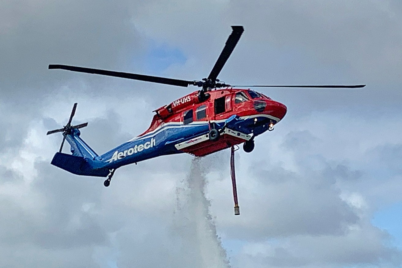 One of Aerotech's two new Black Hawk helicopters demonstrates its firefighting ability in the Adelaide Hills this morning.
