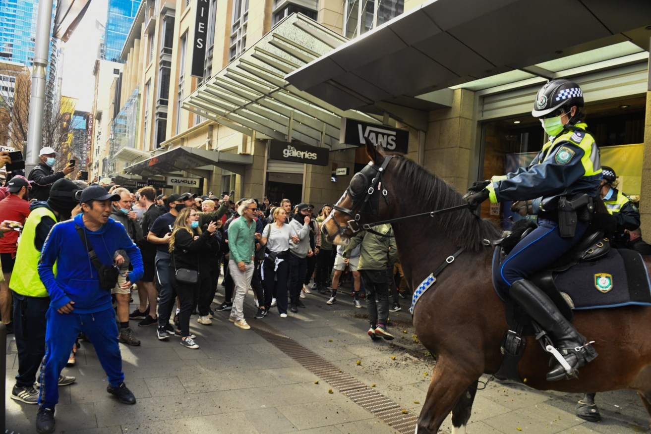 Protesters face off with mounted police at Sydney Town Hall during yesterday's protest. Two men were later arrested for punching police horses. Photo: AAP/Mick Tsikas