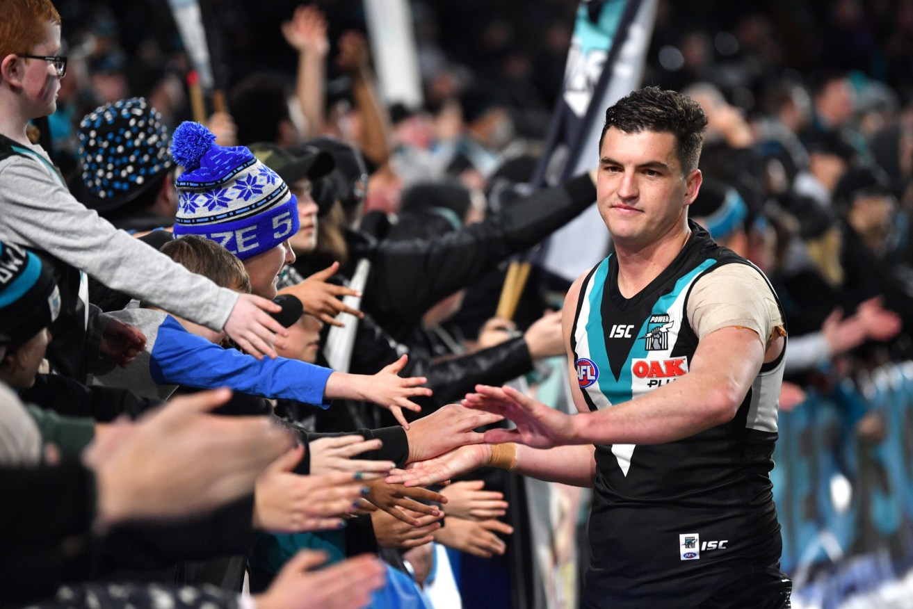 Tom Rockliff of the Power celebrates with fans after a game in 2019 (AAP Image/David Mariuz)