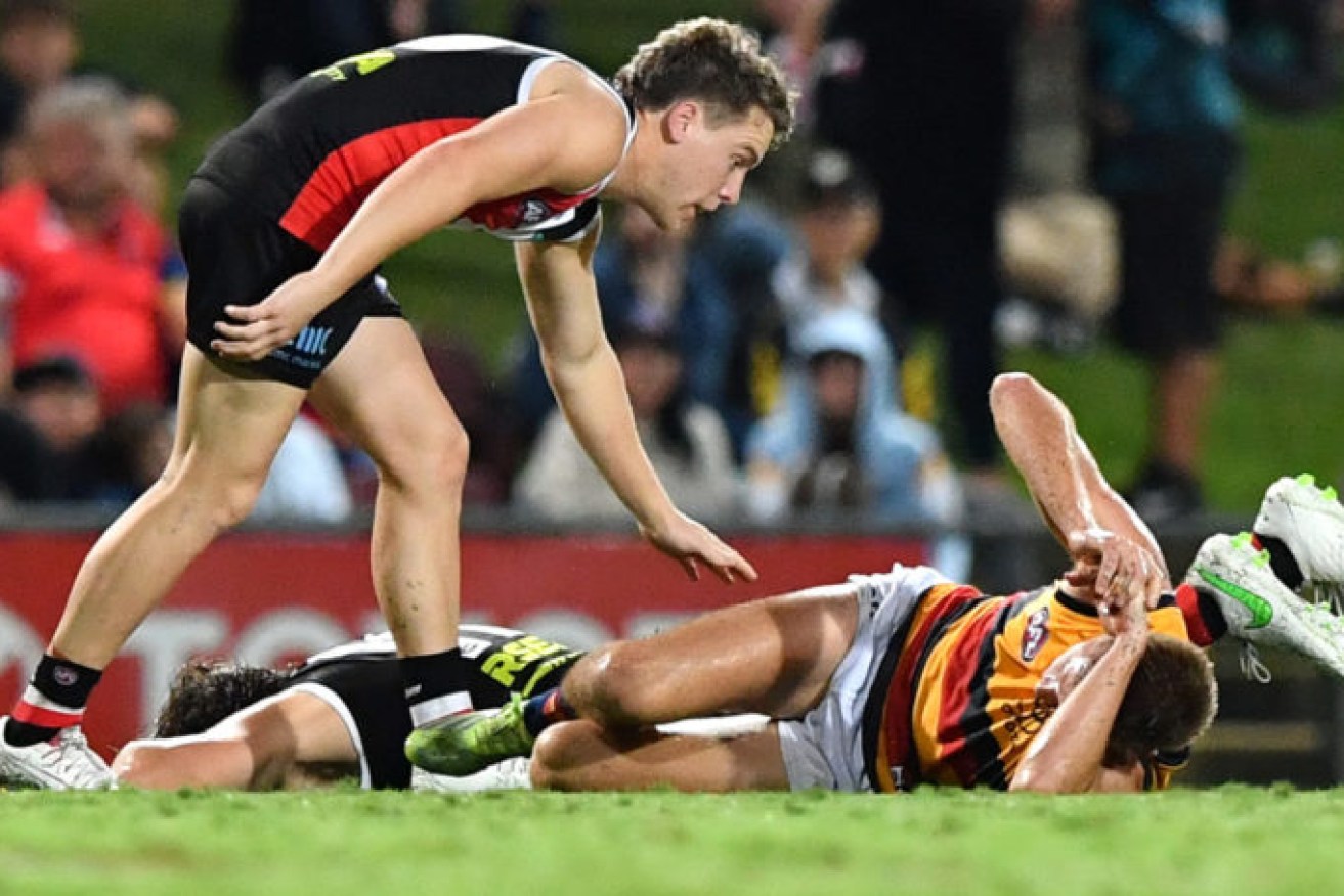 St Kilda's Jack Lonie checks on team mate Hunter Clark and Adelaide's David Mackay after their heavy collision during the round 13 match in Cairns. Photo: AAP/Darren England