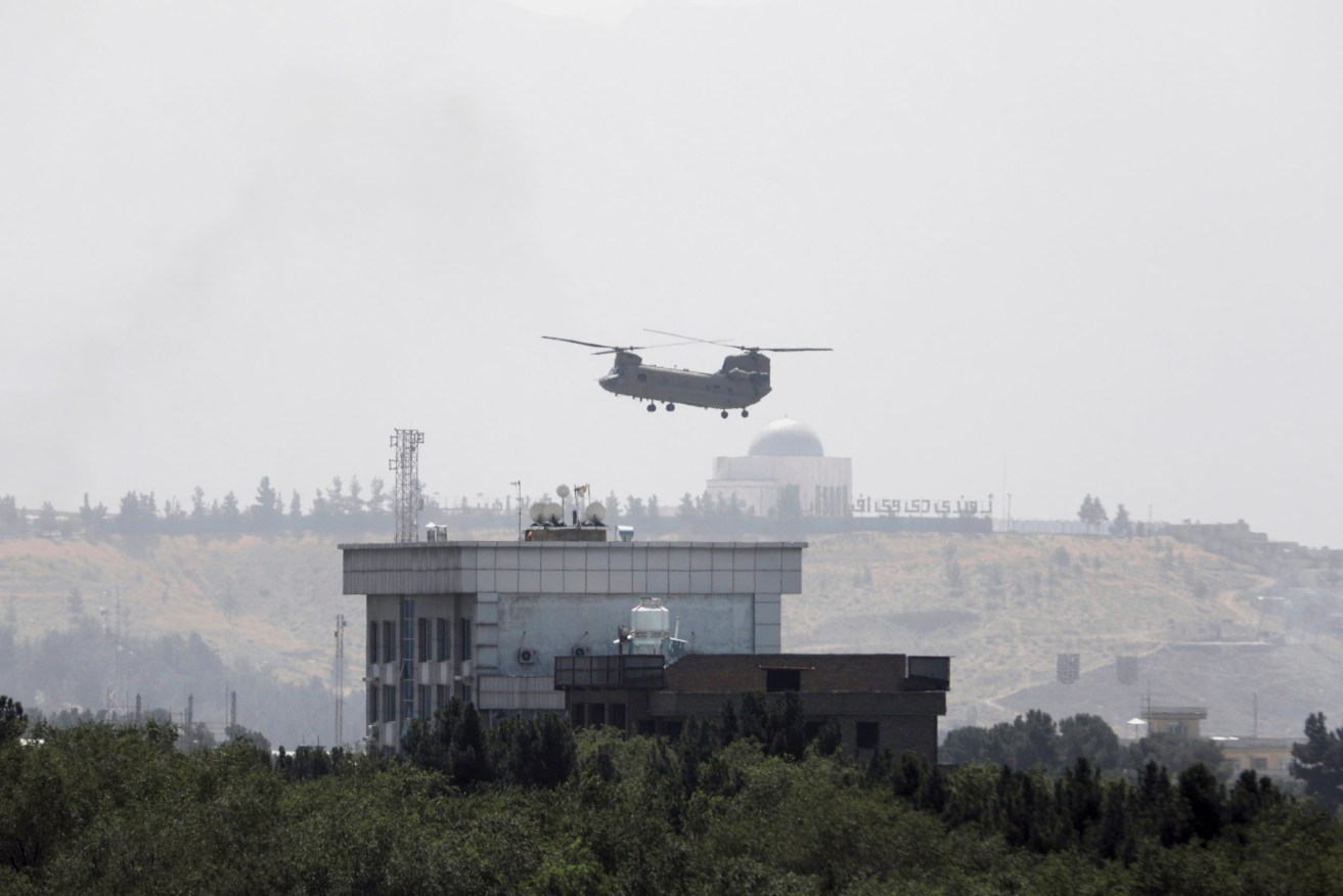 A U.S. Chinook helicopter flies near the U.S. Embassy in Kabul on Sunday as diplomats left the compound amid the Taliban advance. Photo: AP/Rahmat Gul