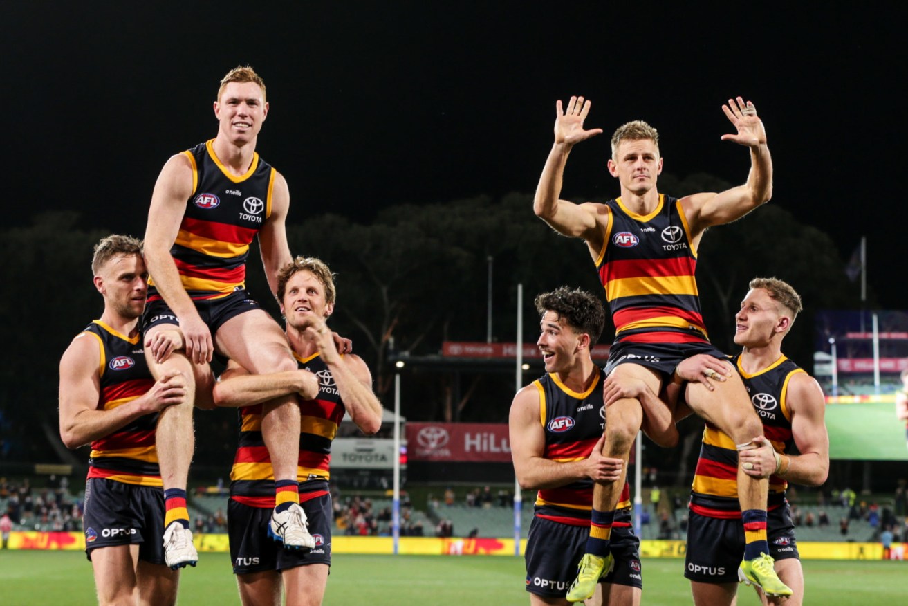 Tom Lynch and David Mackay are chaired off after last weekend's win - their final game for the Crows. Photo:Matt Turner / AAP