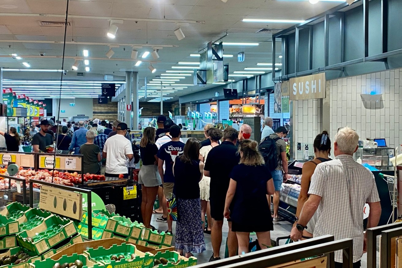 Shoppers queue in a Darwin supermarket after the lockdown announcement. Photo: Tony Lewis/InDaily