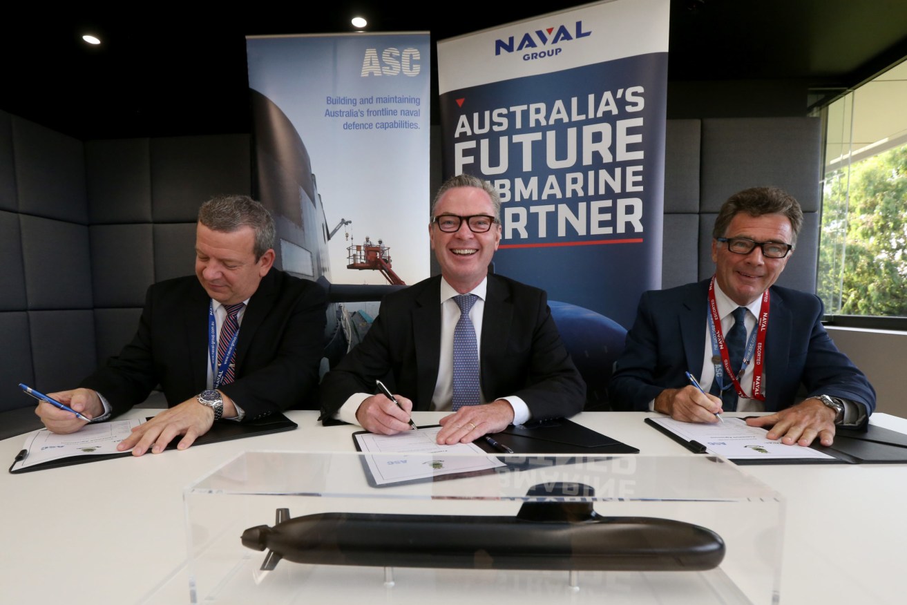 Christopher Pyne signing a working agreement with Naval Group Australia CEO John Davies and ASC CEO Stuart Whiley in 2019. Photo: Kelly Barnes / AAP