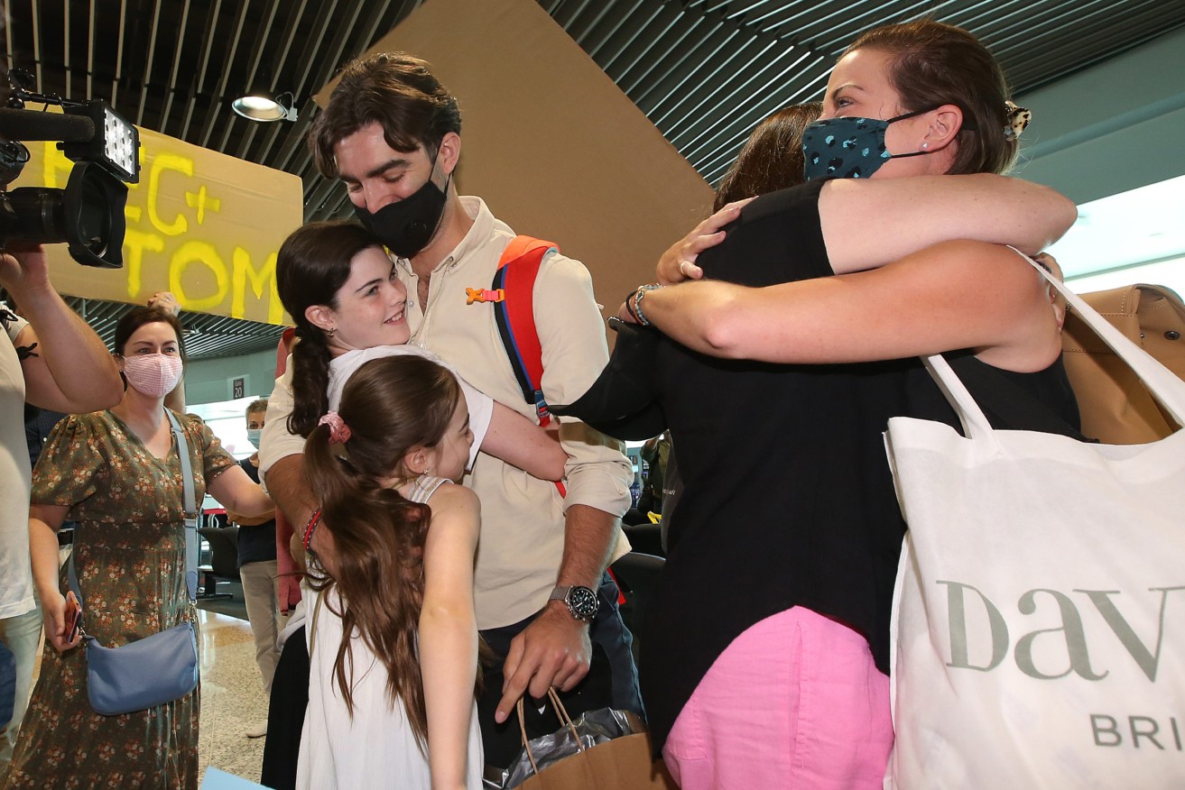 A reunion at Brisbane Airport after Queensland reopened to vaccinated arrivals. Photo: AAP/Jono Searle