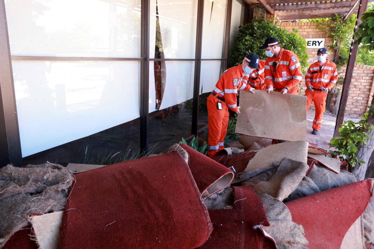 SES members clearing debris after a storm ripped through Port Augusta earlier this month. The increase in natural disasters across the country has prompted concern about access to insurance (AAP Image/Pool, Kelly Barnes)
