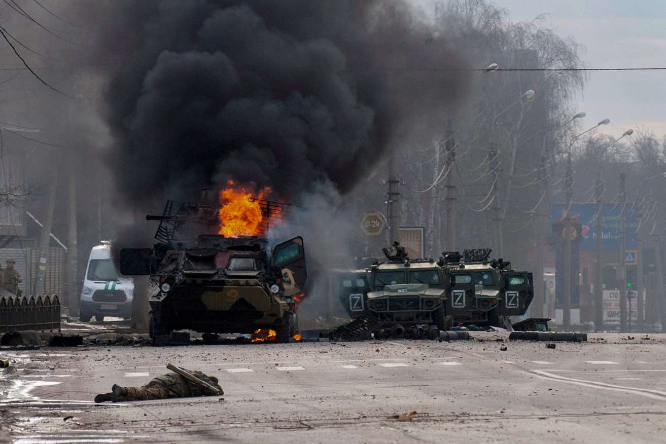 An armored personnel carrier burns and damaged light utility vehicles stand abandoned after fighting in Kharkiv, Ukraine on Sunday, February 27. Picture: Marienko Andrew/AP