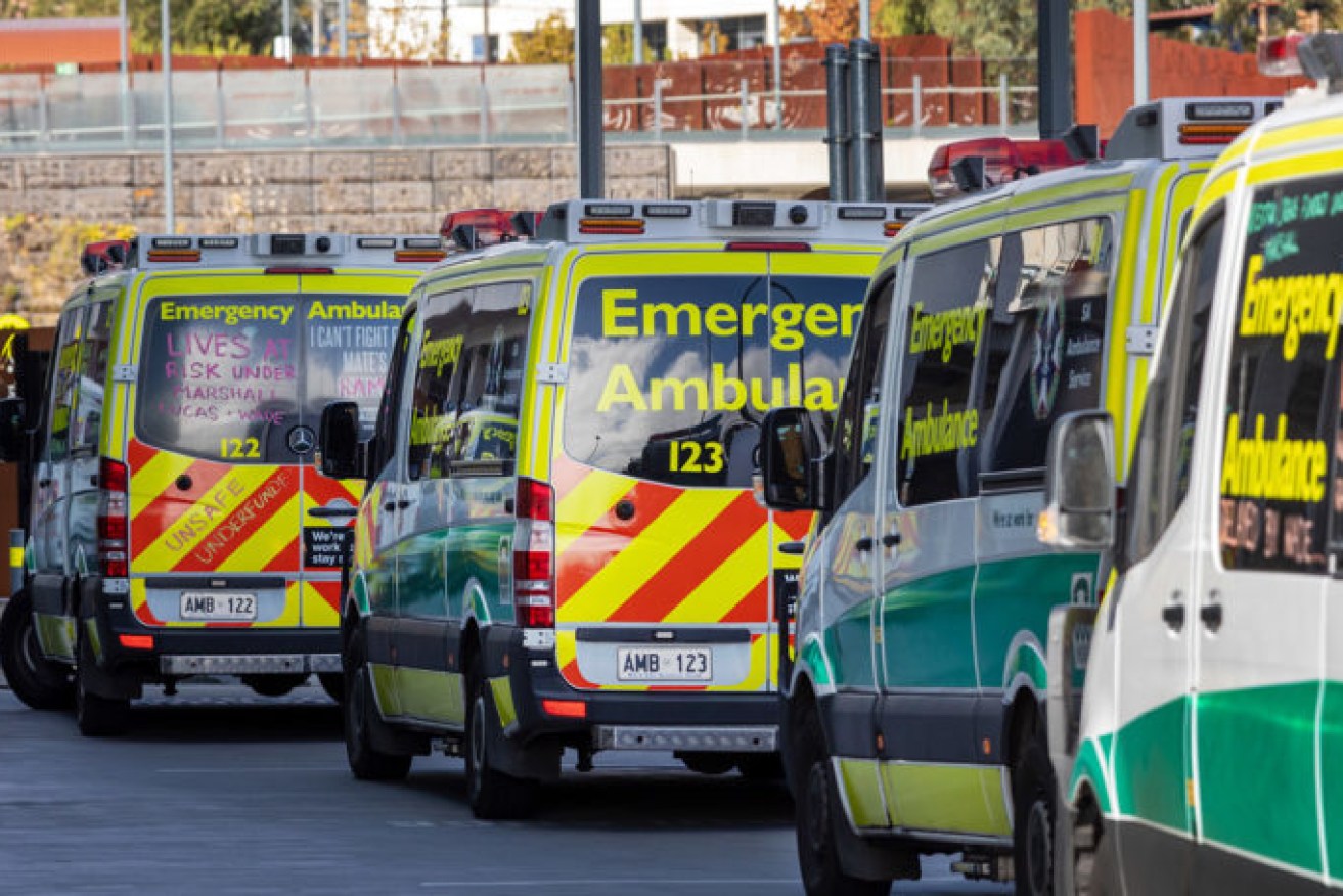 Ramped ambulances with chalked messages, that the ambulance service boss argues are now "electoral advertising". Photo: Tony Lewis/InDaily