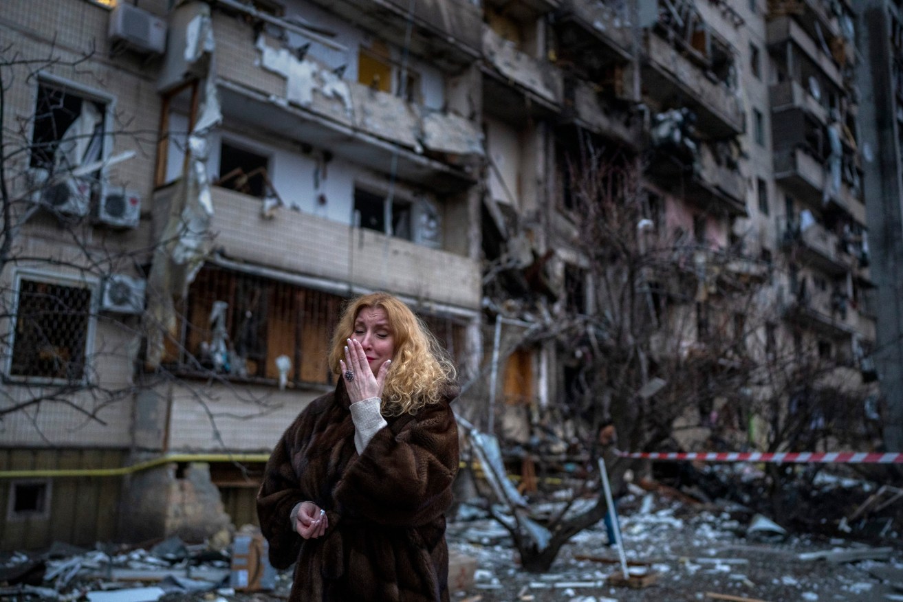 A resident outside her Kyiv apartment block targeted by Russian rockets during the Ukraine invasion. Photo: AP/Emilio Morenatti
