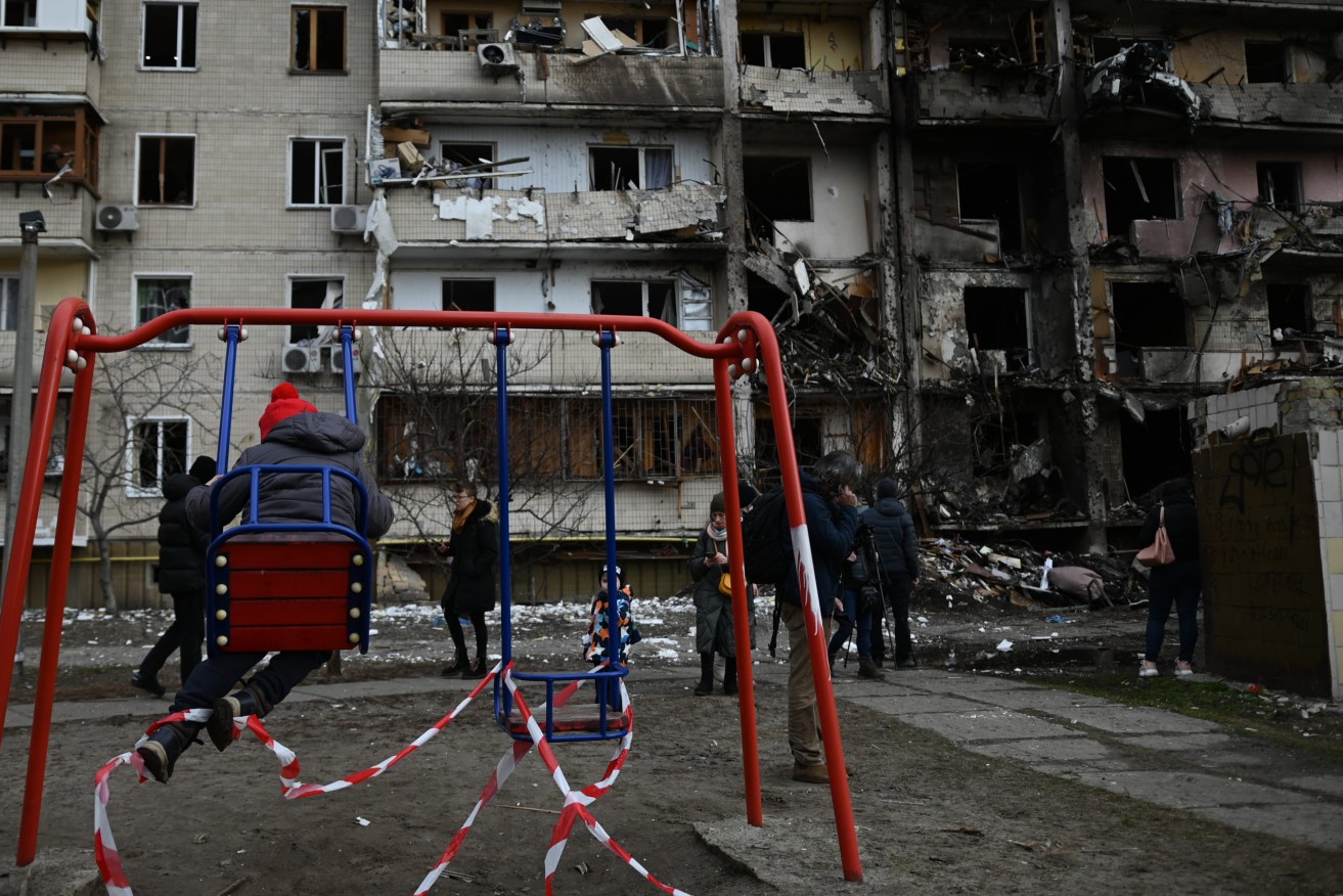 A child plays in front of an apartment building hit by Russian rockets in Kyiv. Photo: Justin Yau/Sipa USA