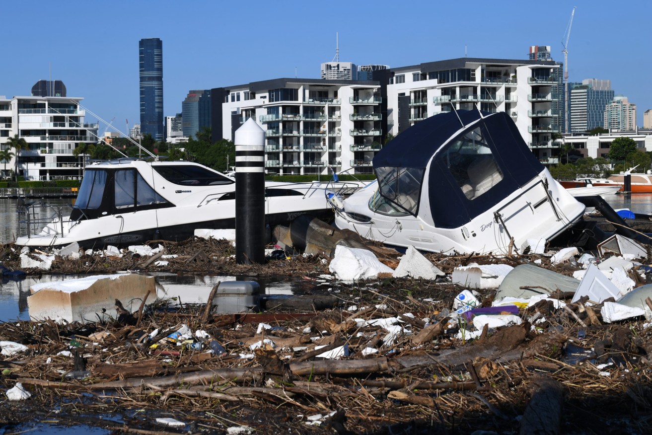 Floodwaters pushed boats and debris into a Brisbane ferry terminal. Photo: AAP/Darren England