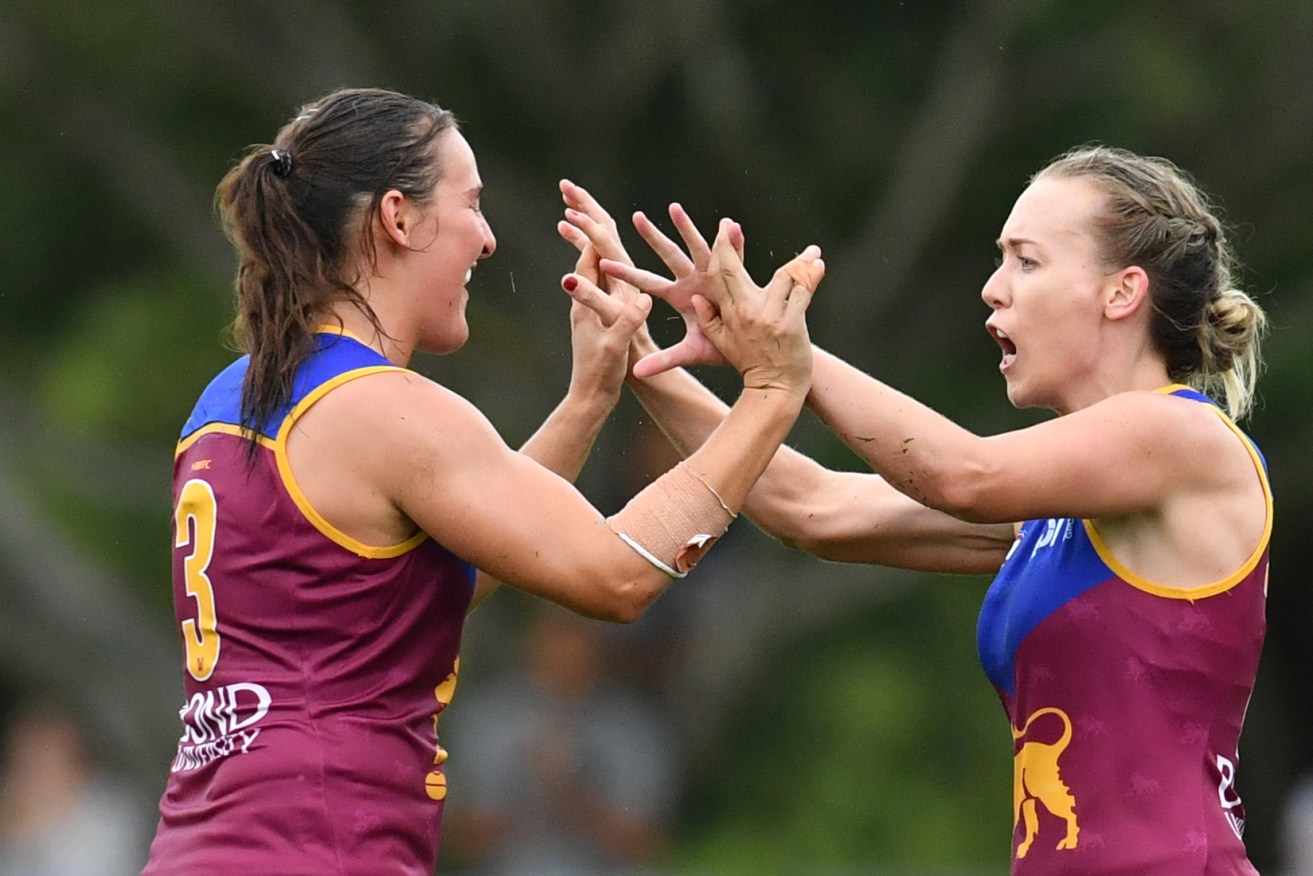 Lauren Arnell (right) celebrates kicking a goal for Brisbane. Photo: Darren England / AAP