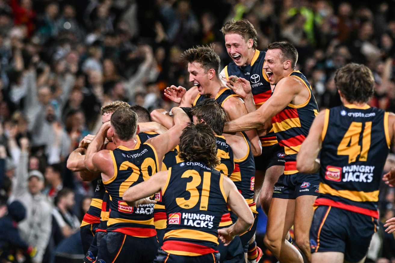 Crows players swamp Jordan Dawson after his clutch goal on Friday night. Photo: Michael Errey / InDaily