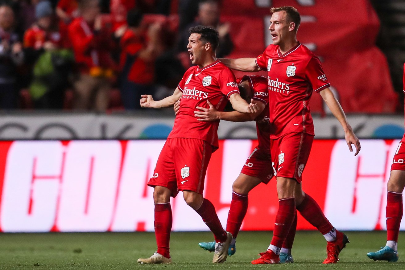Javi López of United celebrates scoring the opening goal with his team mates during last night's clash with Western United. Photo: Matt Turner/AAP