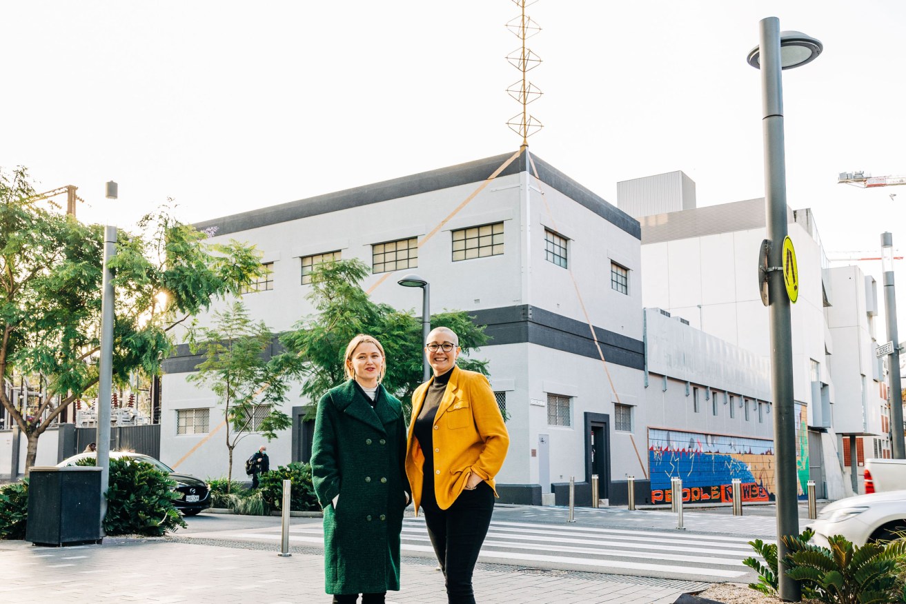 Artists Frances Rogers and Oakey in front of 'Endless Hoist' on the roof of the Hindley Street substation. Photo: Samuel Graves