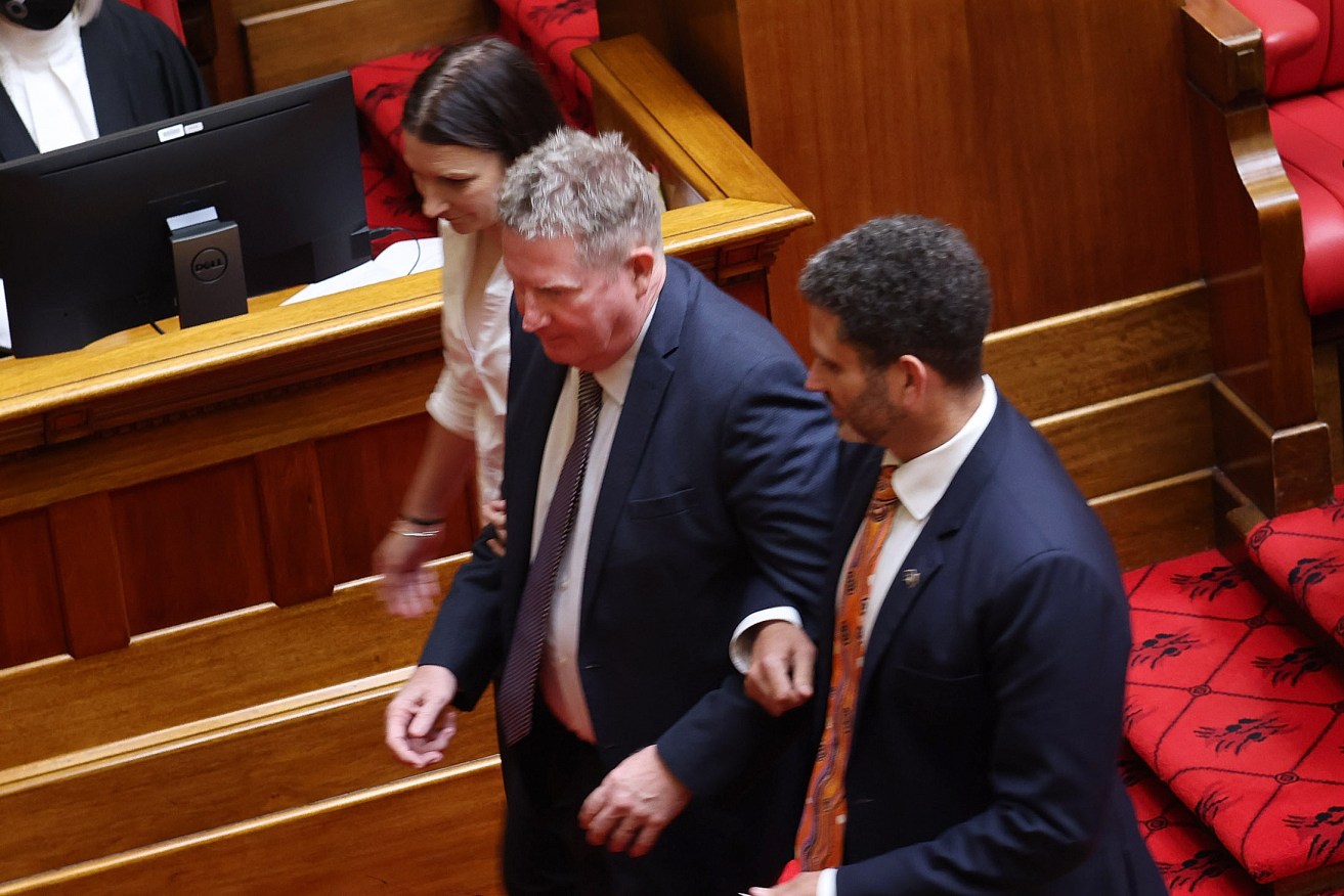 Terry Stephens is escorted by Labor's Kyam Maher and Liberal Nicola Centofanti to the president's chair. Photo: Tony Lewis / InDaily