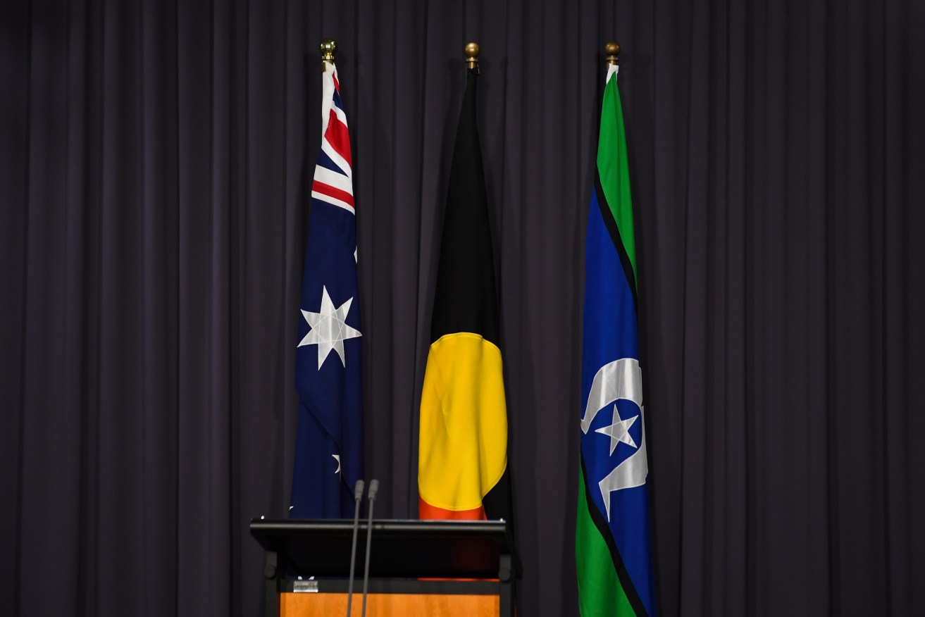 The Australian flag, the Aboriginal flag and the flag of the Torres Straits Islands before an Anthony Albanese press conference at Parliament House, Canberra. Photo: AAP/Lukas Coch