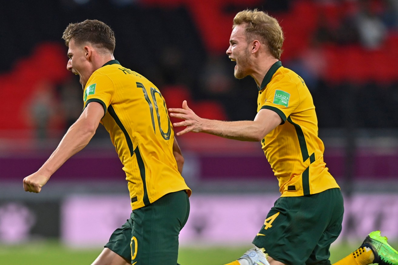 Socceroo Ajdin Hrustic (left) celebrates with teammate Nathaniel Atkinson after scoring to give Australia the 2-1 lead in its World Cup qualifier playoff match against the United Arab Emirates. Photo: Noushad Thekkayil/EPA