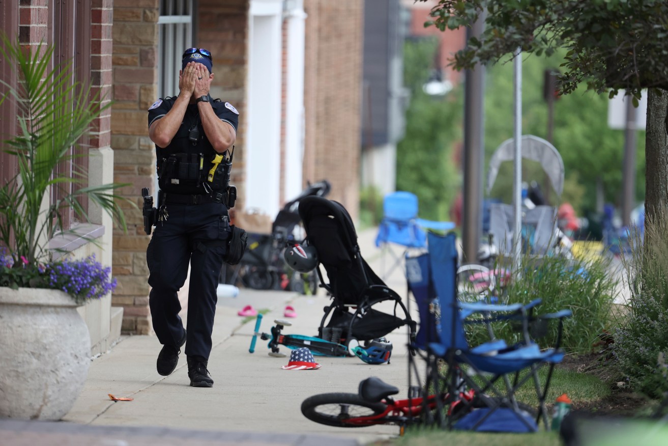 A Lake Forest, Ill., police officer walks down Central Ave in Highland Park, Ill., on Monday, July 4, 2022, after a shooter fired on the northern suburb's Fourth of July parade. Photo: Brian Cassella/Chicago Tribune.
