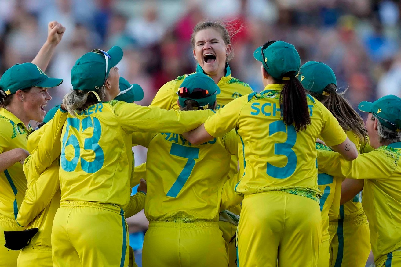 Australia's Jess Jonassen, centre, and teammates celebrate after defeating India at Edgbaston. Photo: AP/Aijaz Rahi