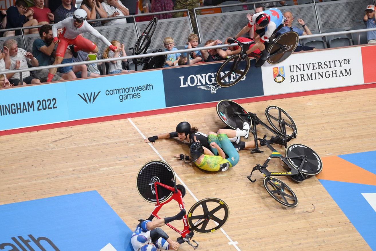 Matt Walls of England (left) crashes over the rail during the Men’s 15km Scratch Race at the Lee Valley VeloPark in London. Photo: Alex Broadway/SWPix/AAP