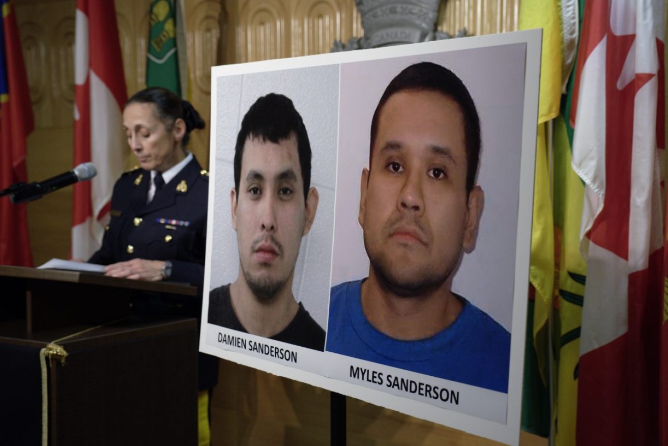 Police with photos of stabbing suspects Damien Sanderson and Myles Sanderson. Damien was later found dead and Myles has been arrested after a four-day search. Photo: Michael Bell/The Canadian Press via AP