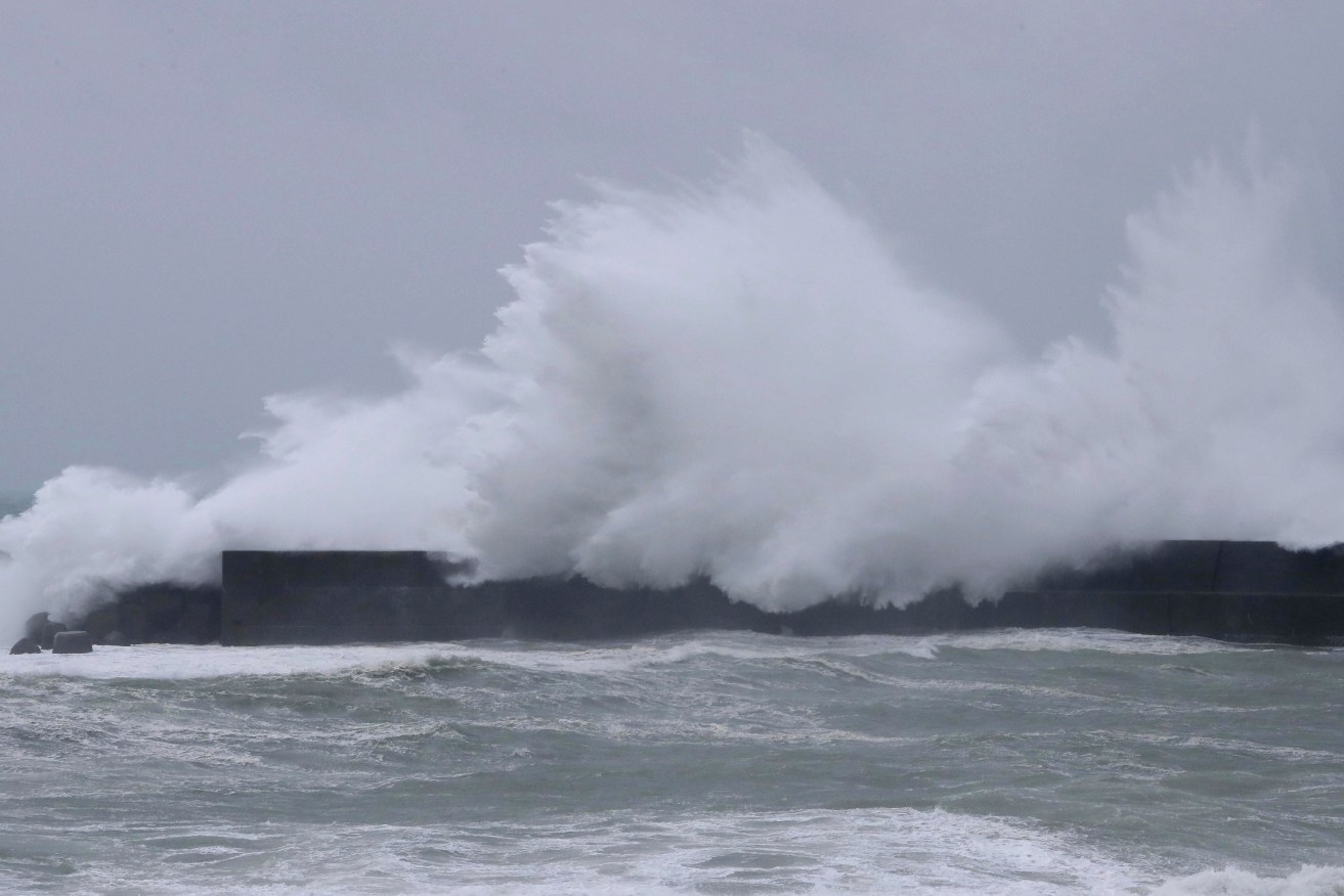 A high wave overflows a breakwater at Haruno Fishery Port in Kochi, Japan. Photo: AP Images