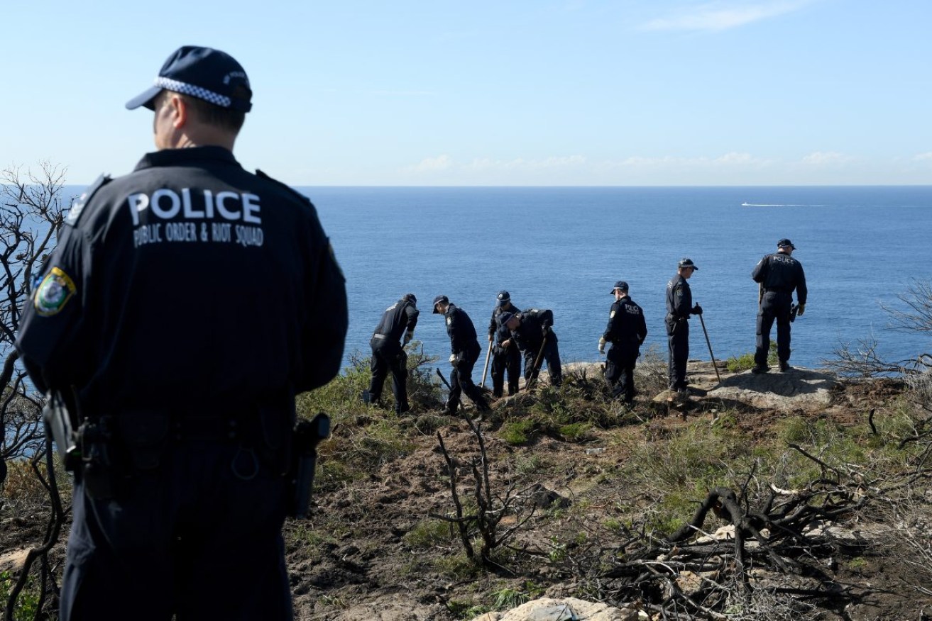 Police search a Sydney cliff after a cold case arrest for a suspected gay-hate murder. Photo: AAP/Dan Himbrechts