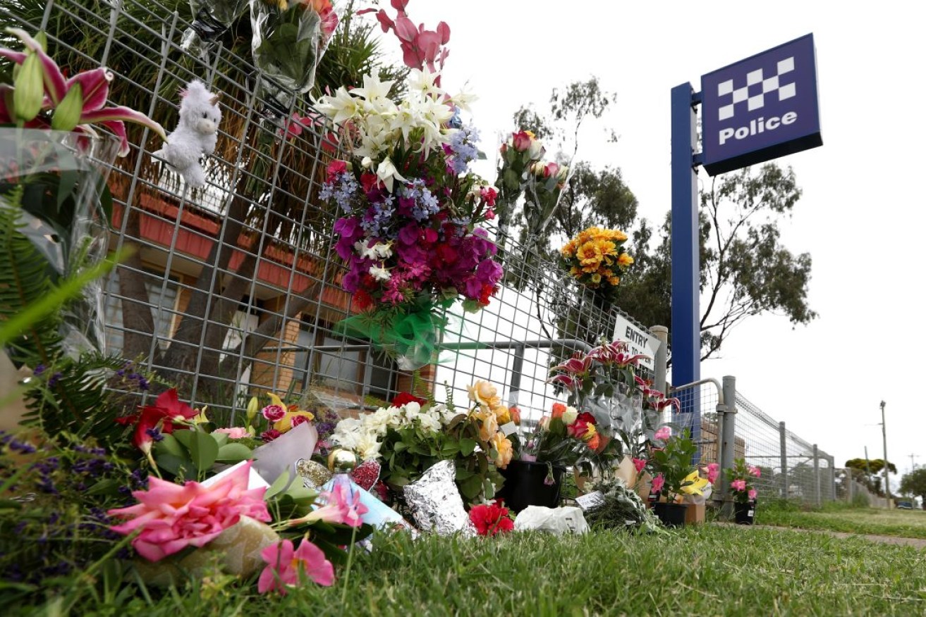 Tributes outside Tara Police station in Queensland after two of its officers were shot dead during a missing persons inquiry at a remote property. Photo: AAP/Jason O'Brien