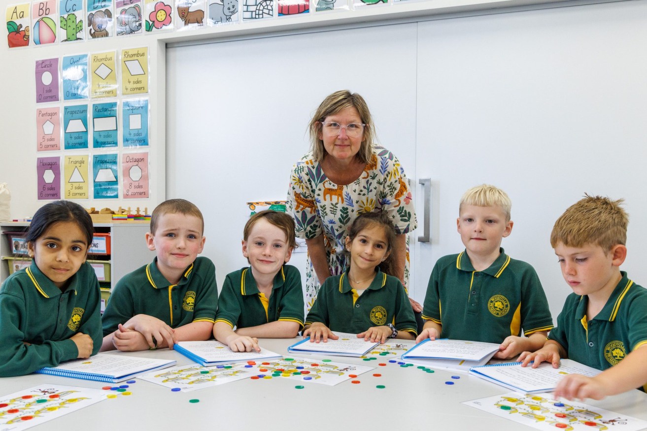 Woodville Primary teacher Olivia O’Halloran helps year one students with their reading. Photo: Tony Lewis/InDaily