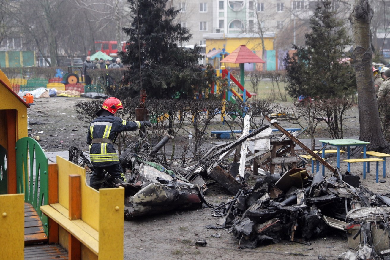 Rescue services remove debris of the helicopter at the scene of a crash in Brovary, near Kyiv. Photo: EPA/Sergey Dolzhenko 