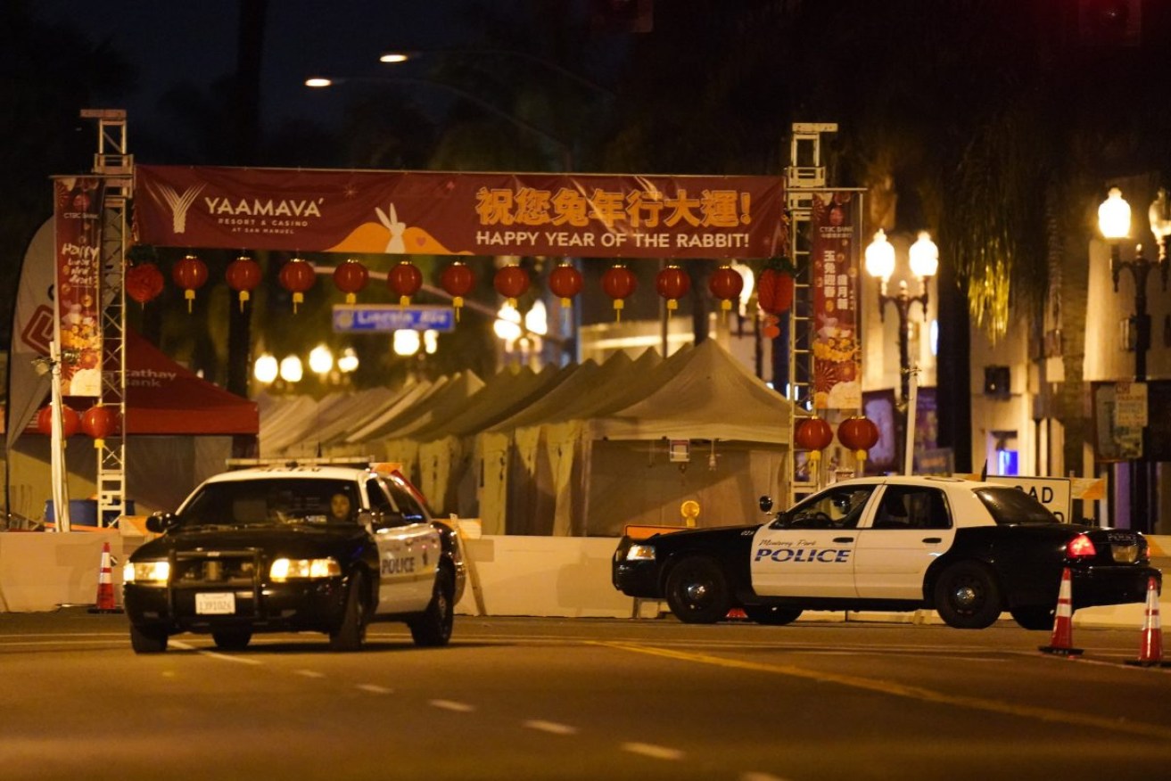 Two police vehicles are seen near a building where a shooting occurred in Los Angeles. Photo: AP/Jae C. Hong