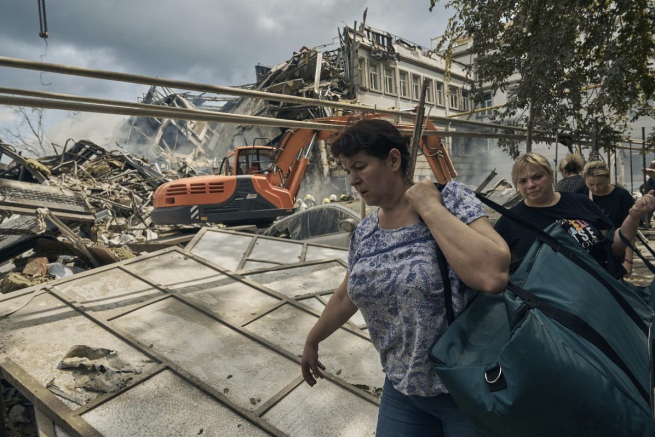 Ukrainians walk past damage from Russian attacks in Odesa. Photo: AP/Libkos