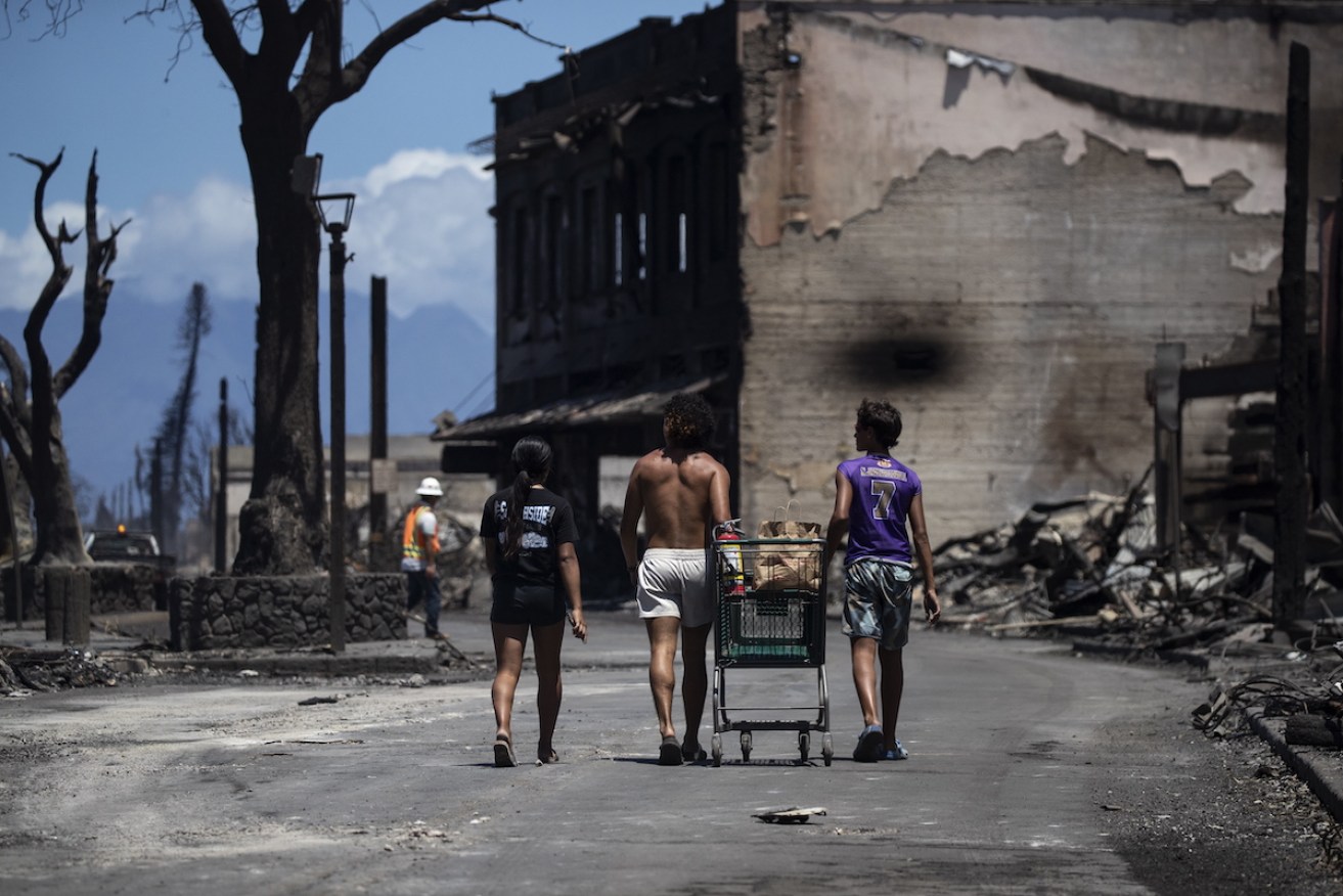 Residents amid the charred ruins of the Maui town of Lahaina. Photo: EPA/ETIENNE LAURENT