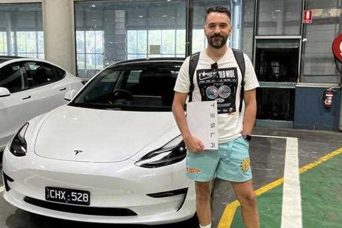 MYOB employee Michael Holt beside his Tesla. Bookkeeping software firm MYOB has launched a new feature to help small businesses offer employees novated car leases. Photo: AAP supplied by MYOB.