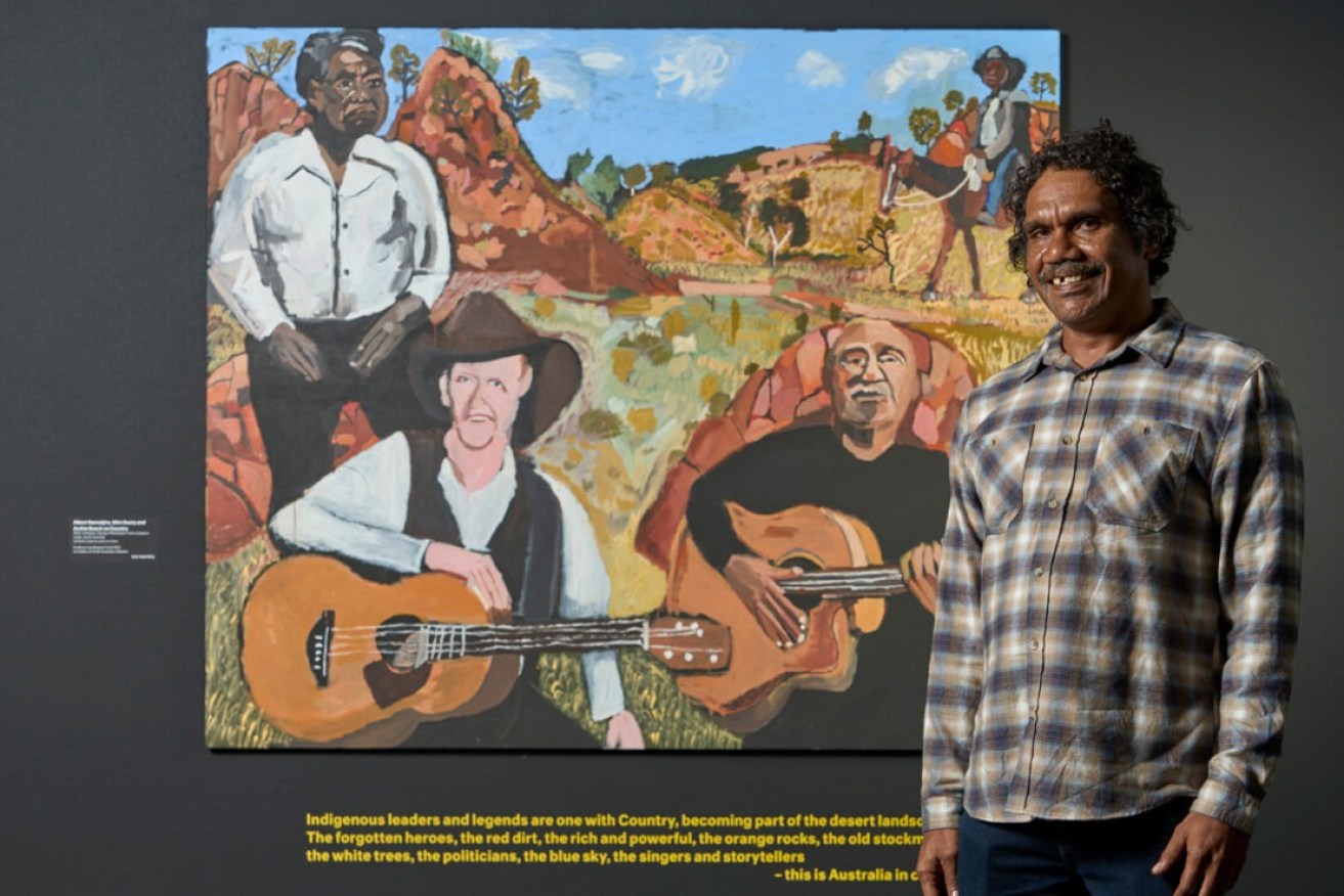 Vincent Namatjira with his work 'Albert Namatjira, Slim Dusty and Archie Roach on Country' in 'Vincent Namatjira: Australia in colour' at the Art Gallery of South Australia. Photo: Sam Roberts / supplied