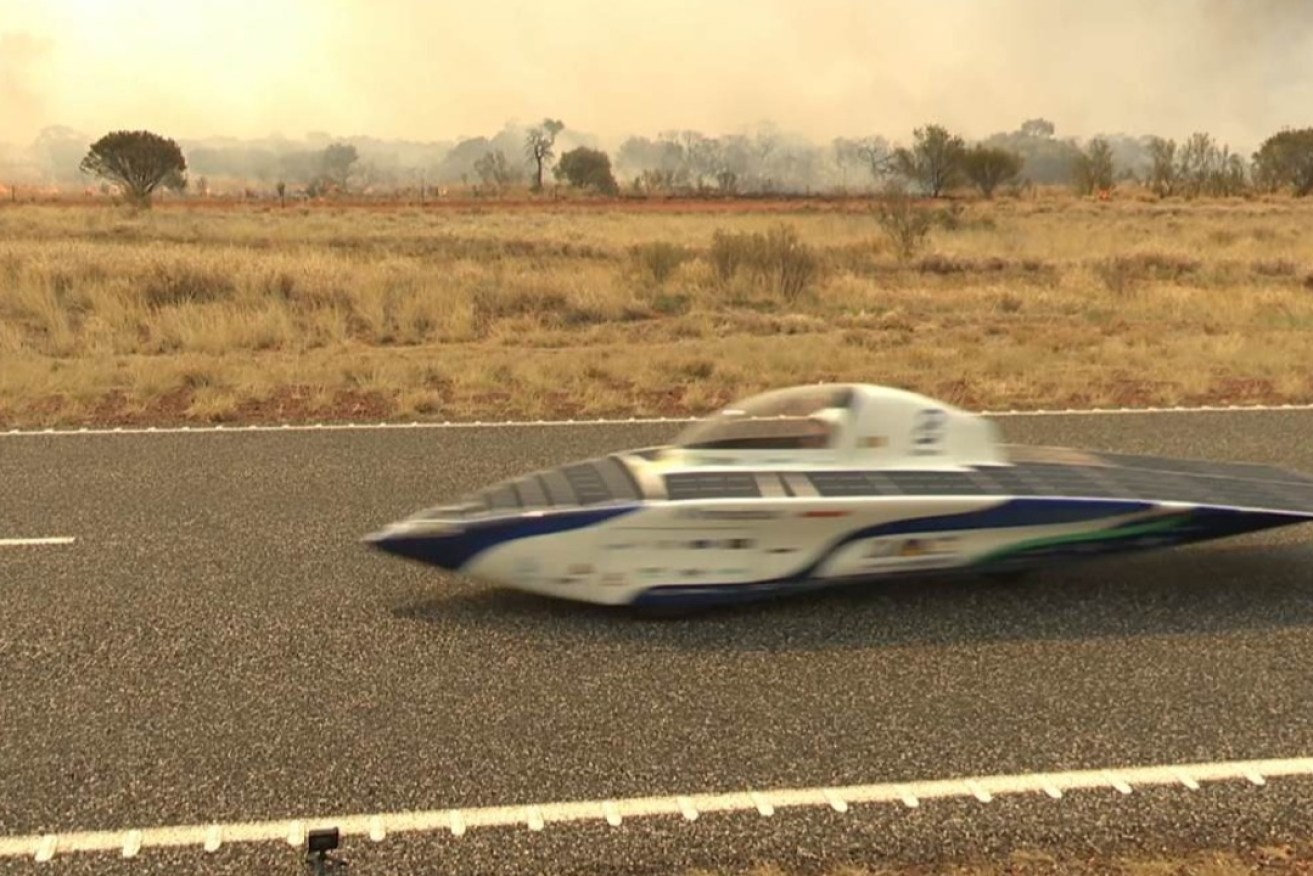 The Innoptus team car ‘Infinite’ zips past fires. Photo: supplied.
